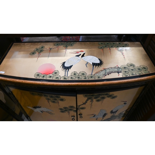 244 - A Japanese gilt and black lacquered two door cabinet decorated with red crowned cranes (Tswu), 82 cm... 