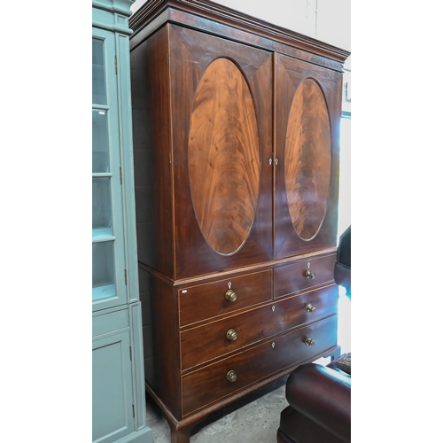 271 - A 19th century mahogany linen press, the top with oval panelled doors enclosing four slides on a che... 