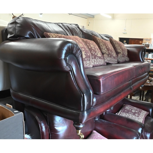 274 - A Thomas Lloyd maroon leather sofa with shaped back and scroll arms, turned mahogany front legs with... 