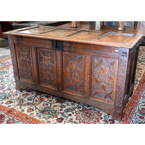 296 - A large 18th century panelled oak coffer with later carved front, the hinged top enclosing storage a... 