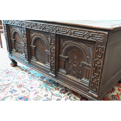 297 - An antique oak coffer with arcade carved panelled front, on bun feet, 132 cm wide x 66 cm deep x 65 ... 