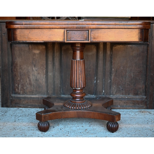 428 - Regency rosewood folding card table, raised on a gadrooned support to a platform base, on castors, 9... 