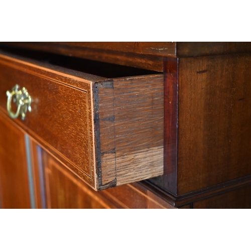 473 - An Edwardian crossbanded satinwood cabinet comprised of a full width drawer over a pair of panelled ... 