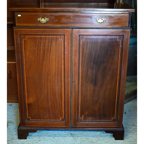 473 - An Edwardian crossbanded satinwood cabinet comprised of a full width drawer over a pair of panelled ... 