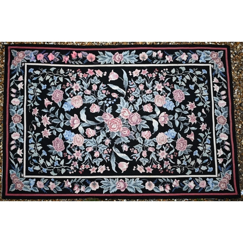 510 - A traditional needlepoint rug, floral design on black ground, 183 x 123 cm