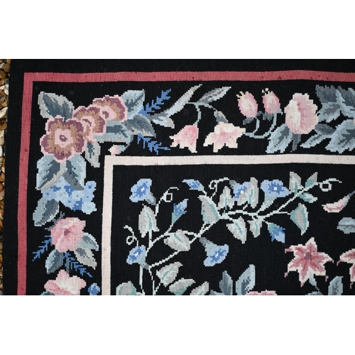 510 - A traditional needlepoint rug, floral design on black ground, 183 x 123 cm