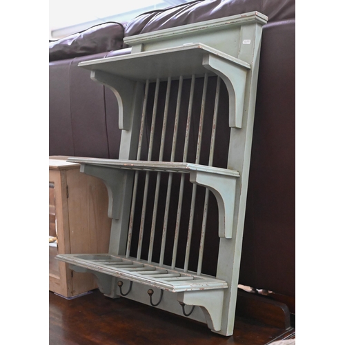 513 - A pale green distress painted three tier wall plate rack with three brass coat hooks beneath, 49 cm ... 