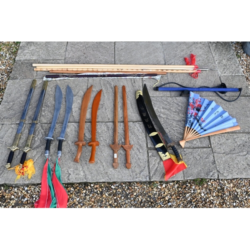 87 - Various reproduction Asian swords, wooden practice swords, fighting staffs, etc