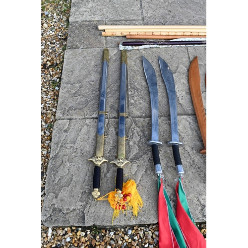 87 - Various reproduction Asian swords, wooden practice swords, fighting staffs, etc