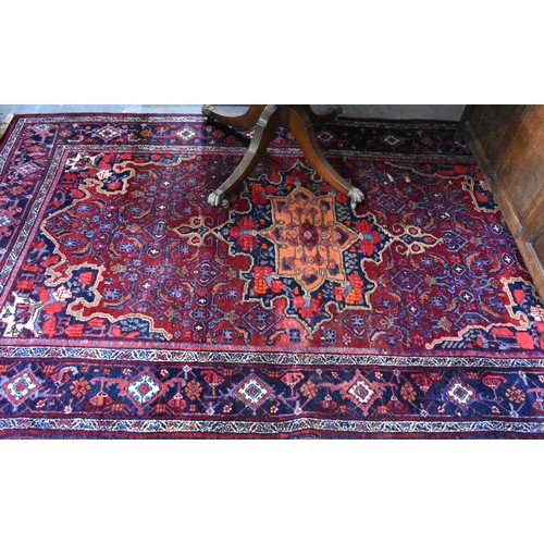 505 - A fine antique Persian hand-made Bidjar rug, the wine-red ground centred by a medallion, 274 cm x 15... 