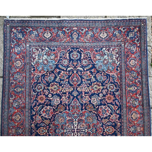 150 - A Persian Kashan rug, palmettes and rosettes arranged symmetrically around the large central floral ... 