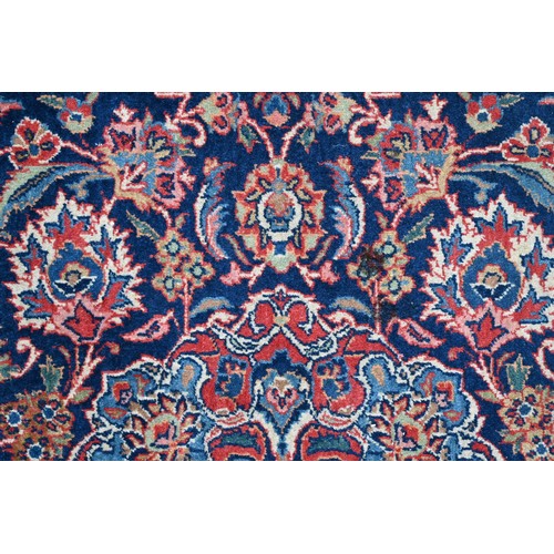 150 - A Persian Kashan rug, palmettes and rosettes arranged symmetrically around the large central floral ... 