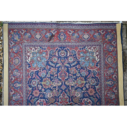 150 - A Persian Kashan rug, palmettes and rosettes arranged symmetrically around the large central floral ... 