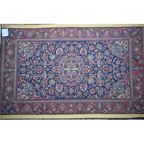 150 - A Persian Kashan rug, palmettes and rosettes arranged symmetrically around the large central floral ... 