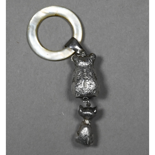 55 - An Edwardian silver baby's rattle with mother of pearl teething ring, hung with teddy bear and grinn... 