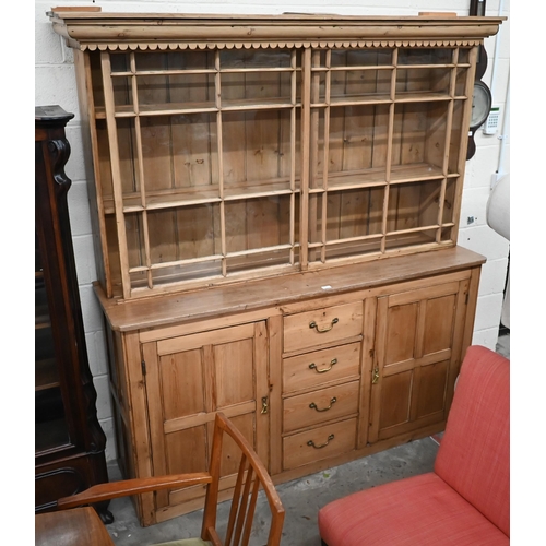 464 - An antique waxed pine kitchen dresser, the raised back fitted with pair of astragal glazed sliding d... 