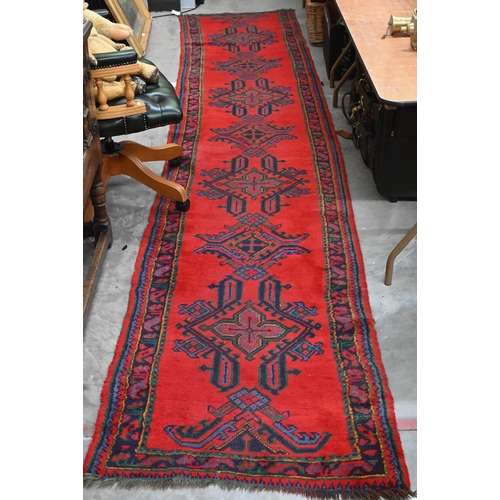 483 - A vintage Turkish red ground runner with geometric design and repeating boteh border, 415 x 82 cm