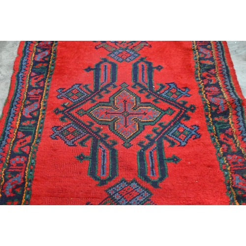 483 - A vintage Turkish red ground runner with geometric design and repeating boteh border, 415 x 82 cm