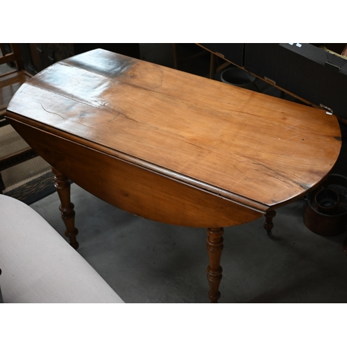 486 - An old french pine drop leaf dining table on turned legs with casters