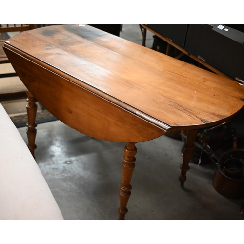 486 - An old french pine drop leaf dining table on turned legs with casters