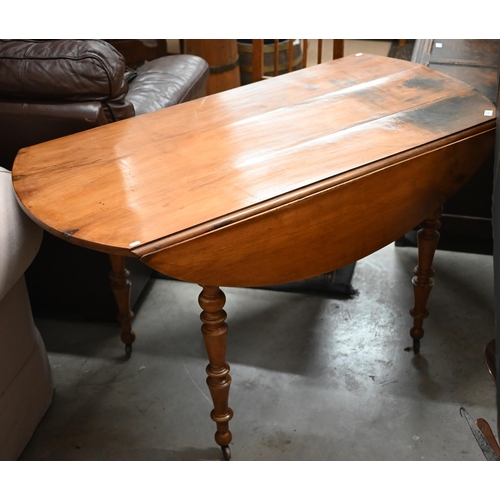 486 - An old french pine drop leaf dining table on turned legs with casters