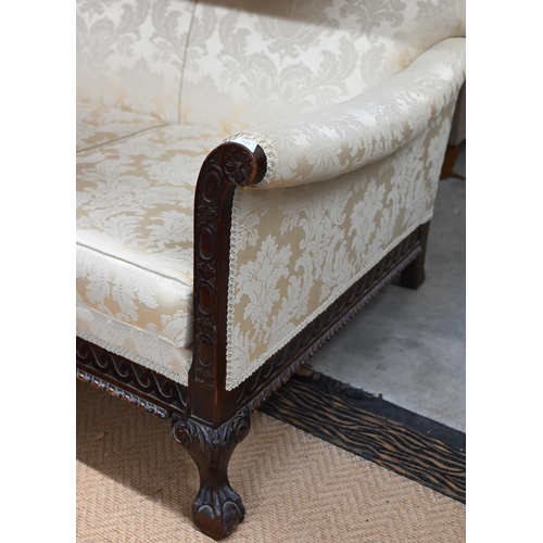 491 - A carved mahogany wing-armed sofa, in old gold damask upholstery, three ball and claw front supports... 