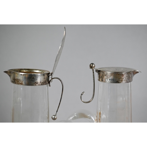 139 - Matched pair of Edwardian cut glass claret jugs with flared bases and silver collars and covers with... 