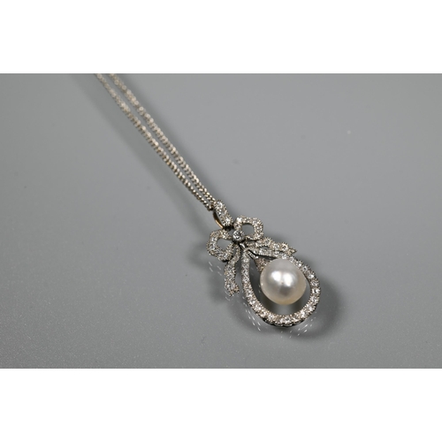 213 - A Belle Epoque diamond and pearl pendant, the old cut diamond-set bow above a tear-shaped diamond se... 