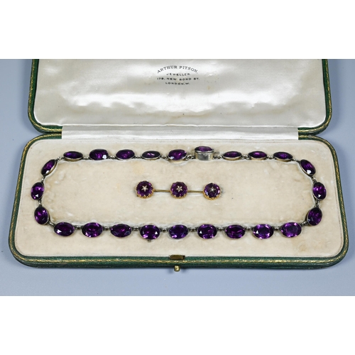 223 - A Victorian rivière necklace, formed of twenty four foil-backed oval faceted purple pastes in gilt m... 