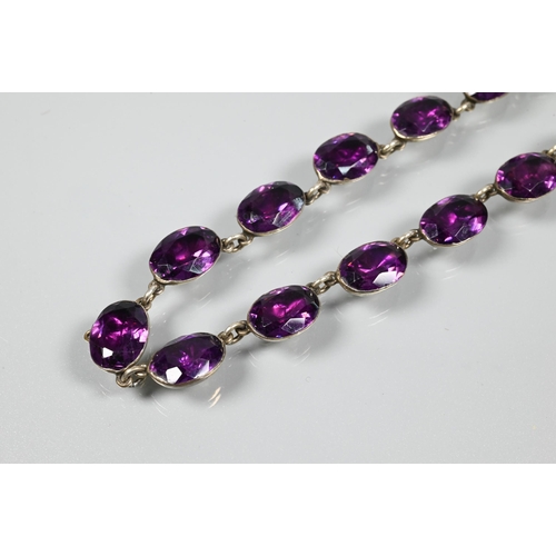 223 - A Victorian rivière necklace, formed of twenty four foil-backed oval faceted purple pastes in gilt m... 