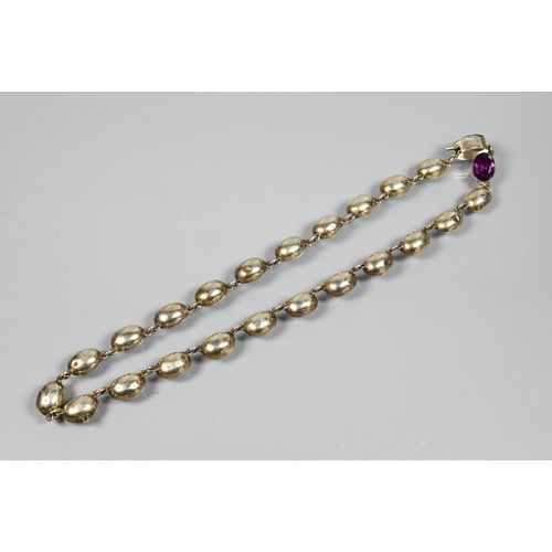 223 - A Victorian rivière necklace, formed of twenty four foil-backed oval faceted purple pastes in gilt m... 