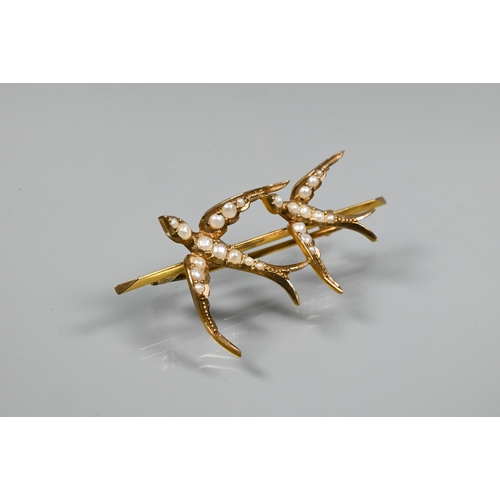 240 - A Victorian 9ct yellow gold bar brooch with two flying swallows with outstretched wings, set overall... 