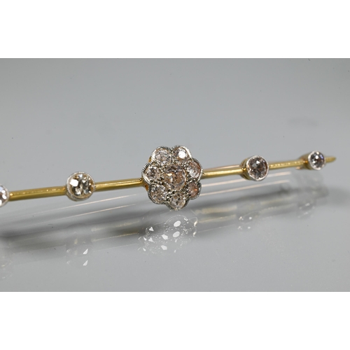 244 - An early 20th century bar brooch featuring a central diamond set daisy cluster, with two further dia... 