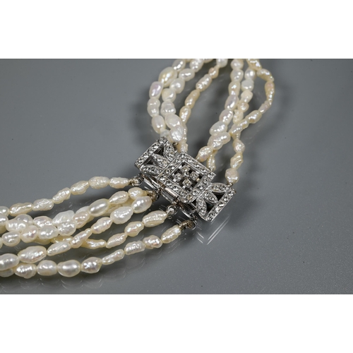 247 - A choker-style necklace formed of six rows of river pearls on to white metal paste-set rectangular c... 