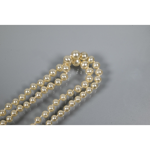 250 - A graduated double row of pearls, double knotted throughout onto green and white paste-set snap stam... 