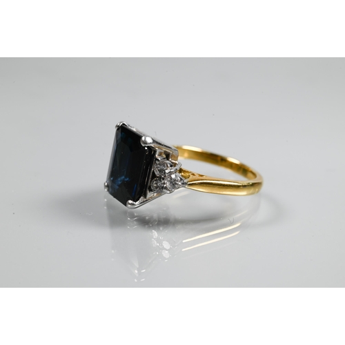 250A - An Art Deco style ring set with rectangular dark blue sapphire (probably), with triple diamond set s... 