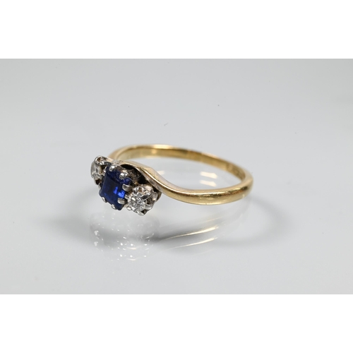 257 - A sapphire and diamond three stone ring in crossover setting, the square blue sapphire flanked by a ... 