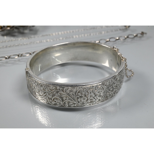 265 - A small collection of white metal jewellery including silver oval half-hinged bangle with chased fol... 