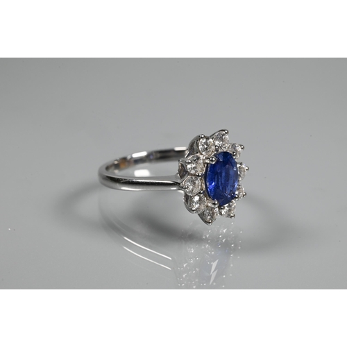 277 - An oval cluster ring, the central oval tanzanite (possibly) surrounded by ten claw set diamonds, sta... 