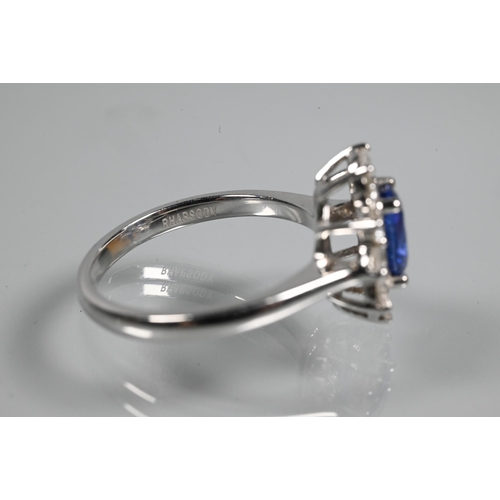 277 - An oval cluster ring, the central oval tanzanite (possibly) surrounded by ten claw set diamonds, sta... 