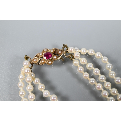 280A - A triple row of graduated cultured pearls double knotted throughout onto ruby and pearl set snap, 9c... 