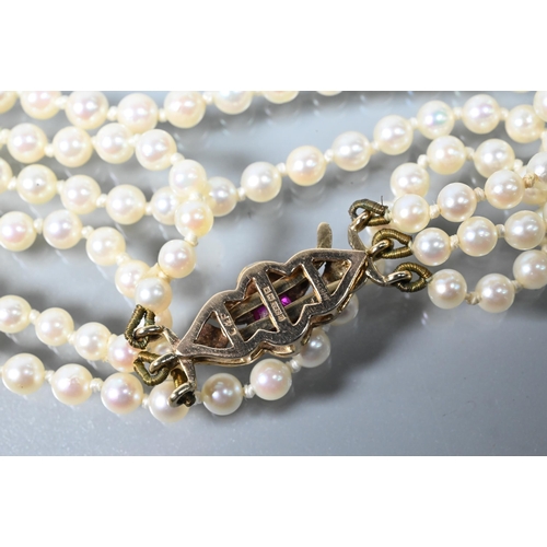 280A - A triple row of graduated cultured pearls double knotted throughout onto ruby and pearl set snap, 9c... 