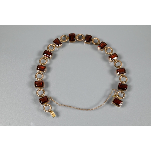 290 - A garnet set bracelet, the rectangular garnet set links interspersed with circular chain links, conc... 