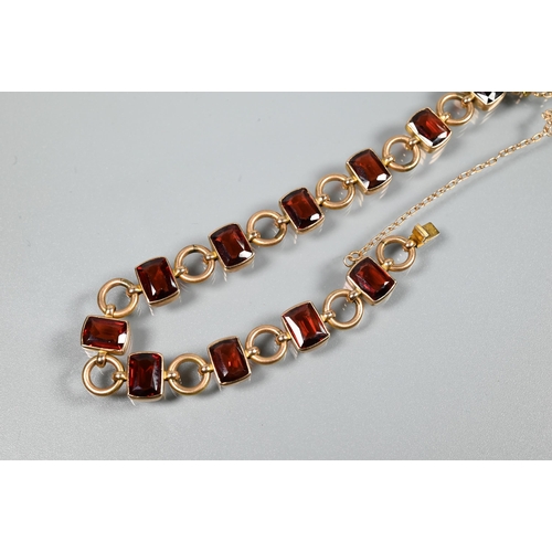 290 - A garnet set bracelet, the rectangular garnet set links interspersed with circular chain links, conc... 