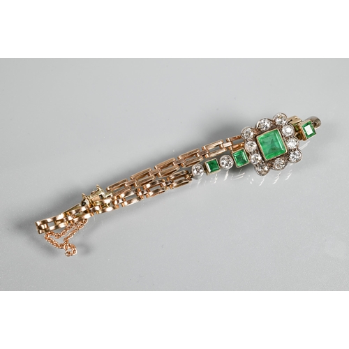 318 - An emerald and diamond cluster bracelet, the central rectangular baguette cut emerald surrounded by ... 