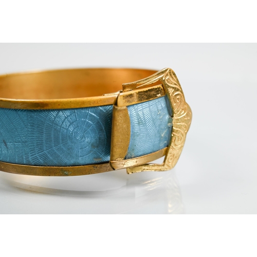 321 - A gilt metal and turquoise enamel bangle in the form of a buckle with stylised 'spider web' enamel d... 