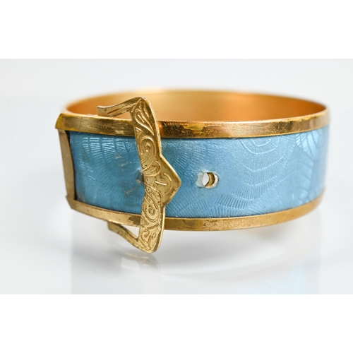 321 - A gilt metal and turquoise enamel bangle in the form of a buckle with stylised 'spider web' enamel d... 