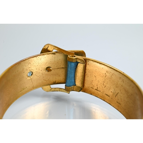 321 - A gilt metal and turquoise enamel bangle in the form of a buckle with stylised 'spider web' enamel d... 