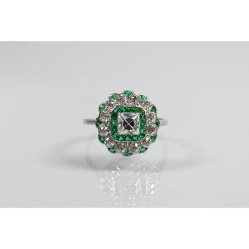 328 - An Art Deco cluster ring, the central assher cut diamond surrounded by a band of square cut emeralds... 