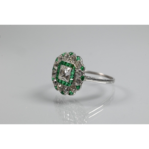 328 - An Art Deco cluster ring, the central assher cut diamond surrounded by a band of square cut emeralds... 